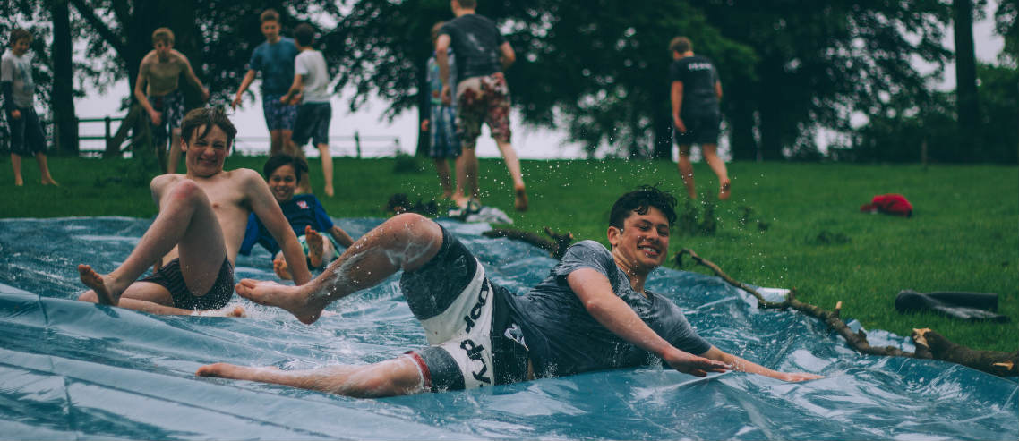 boys play on a slip and slide at the park promoting the benefits of free play